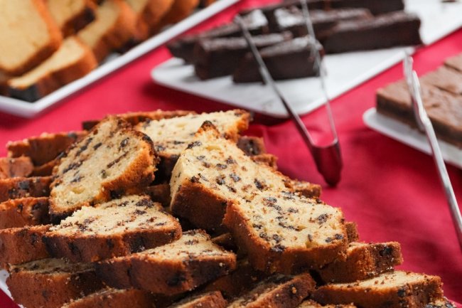 Fette di plumcake ai pezzi di cioccolato su tovaglia rossa.