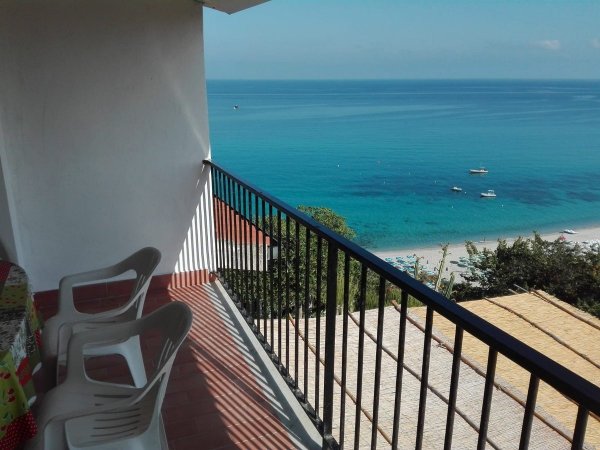 Balcone con sedie bianche e vista sull'oceano.