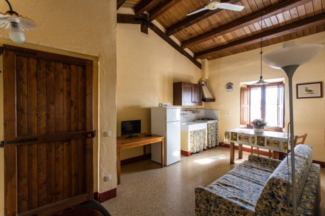 Soggiorno con cucina, tavolo e divano.