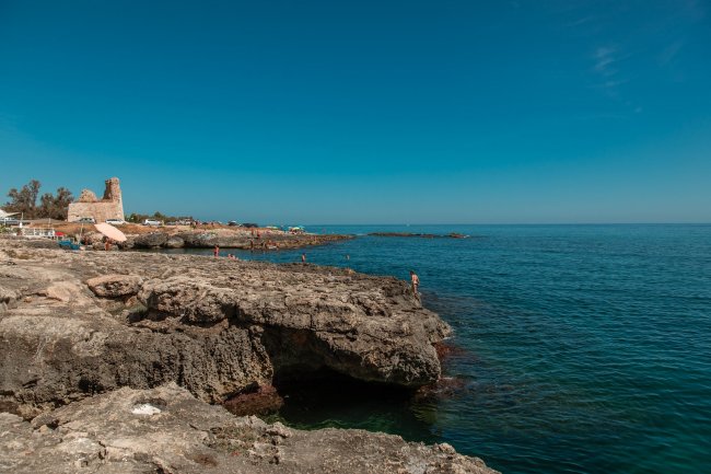 Scogliera e mare blu sotto un cielo sereno.