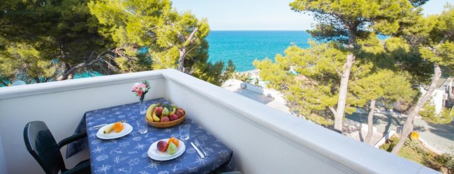 Terrazza con vista mare e tavolo con frutta.