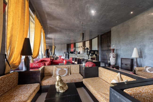 Salotto elegante con arredi orientali e statue dorate.