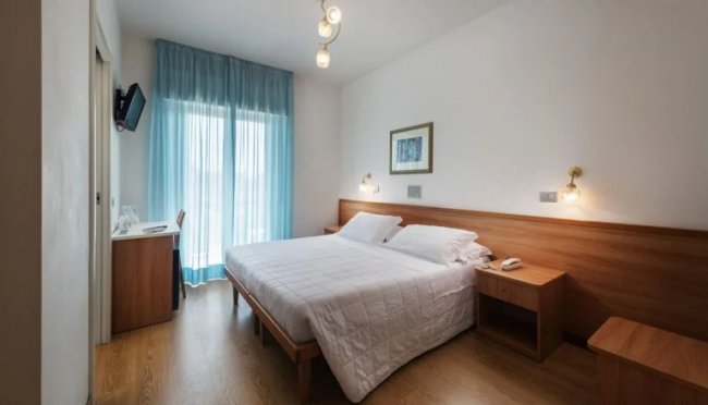 Camera da letto con letto matrimoniale, arredamento semplice.