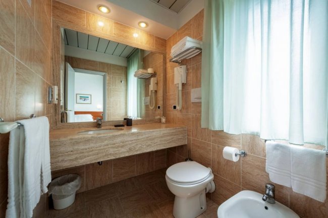 Bagno moderno con lavabo e grande specchio.