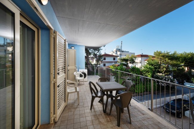 Terrazza con tavolo, sedie e vista su giardino.