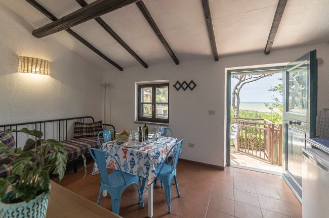 Soggiorno con tavolo e vista sul mare.