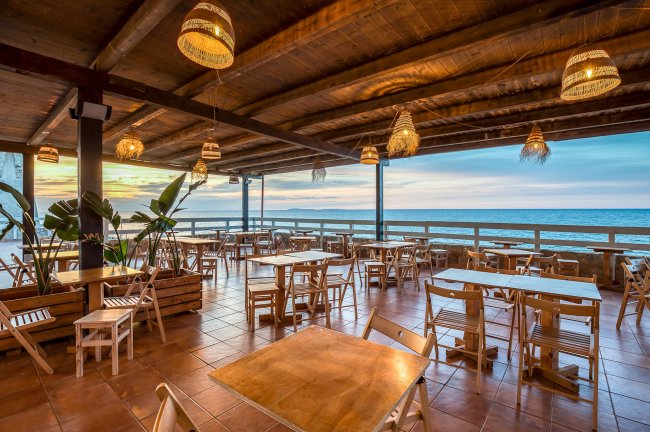 Ristorante vista mare con sedie e tavoli.