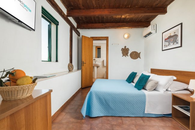 Camera da letto con letto matrimoniale e decorazioni marine.