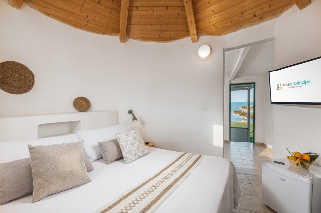 Camera con letto, TV e vista sul mare.