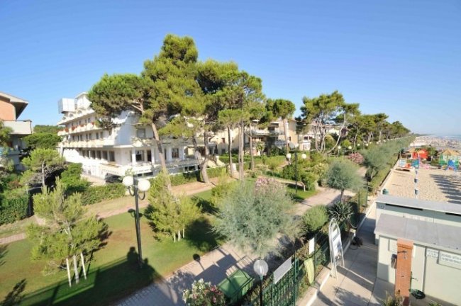 Vista di un giardino alberato e una spiaggia.