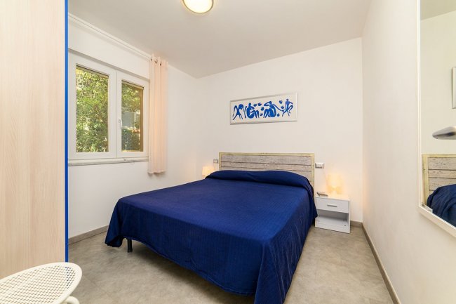 Camera con letto matrimoniale blu.