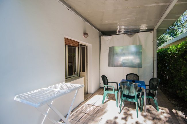 Veranda con tavolo, sedie e stendibiancheria.