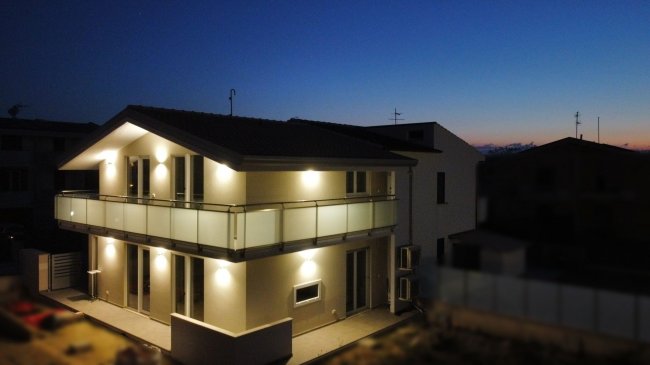 Edificio moderno a due piani illuminato al tramonto.