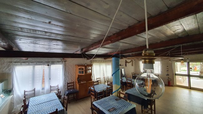 Sala da pranzo con tavoli apparecchiati e decorazioni in legno.