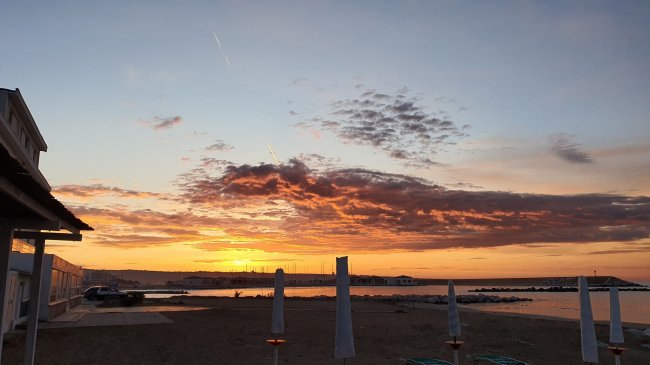 Tramonto sugli ombrelloni in spiaggia.