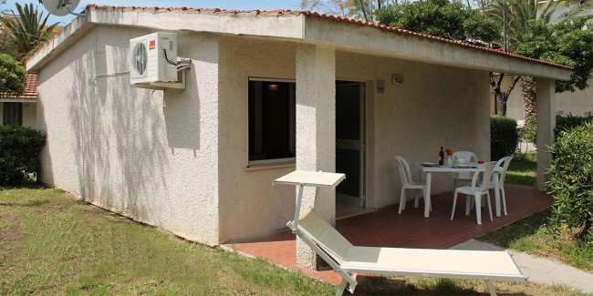 Bungalow con patio e sedie da esterno.