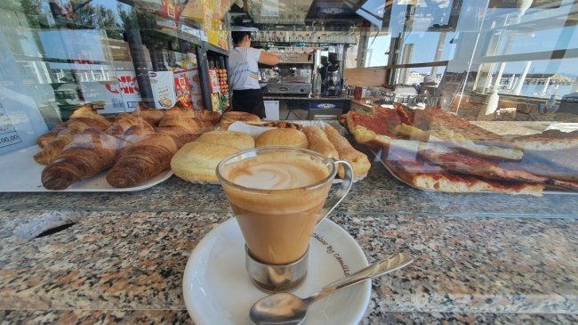 Vetrina con pasticcini e cappuccino al bar.