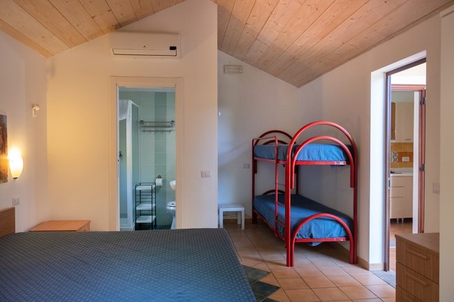 Camera con letto matrimoniale e letti a castello.