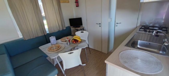 Interno moderno con tavolo da pranzo e cucina.