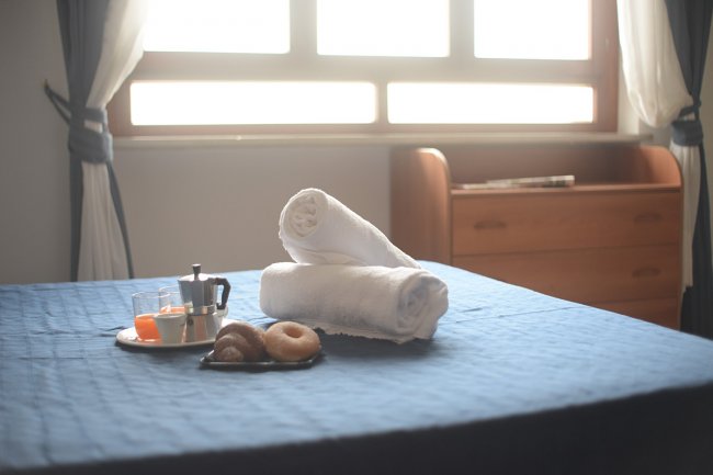 Camera da letto con asciugamani e colazione sul letto.