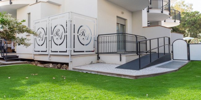 Ingresso con rampa e erba verde.