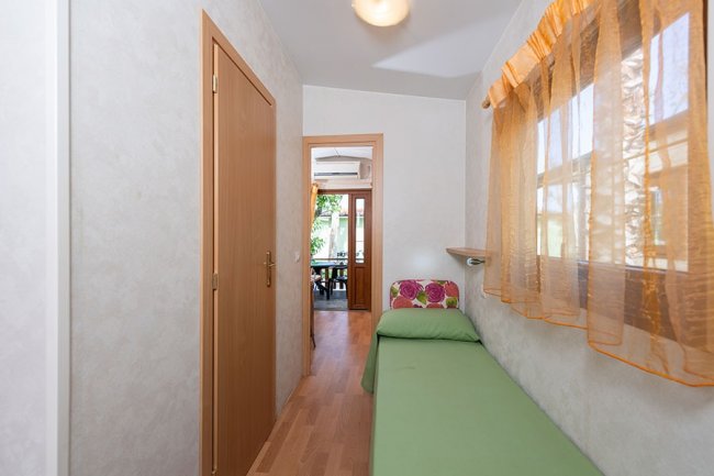 Corridoio con finestra e letto singolo verde.