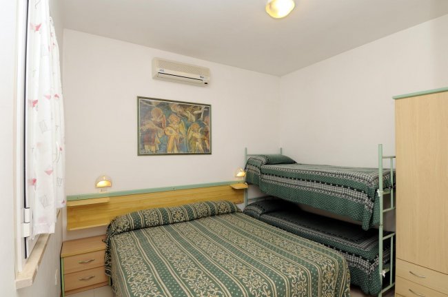 Camera con letto matrimoniale e letti a castello.