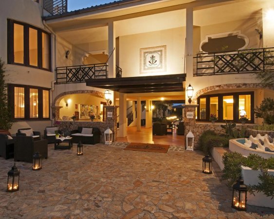 Ingresso accogliente con arredi eleganti, lanterne e ampio cortile in pietra.