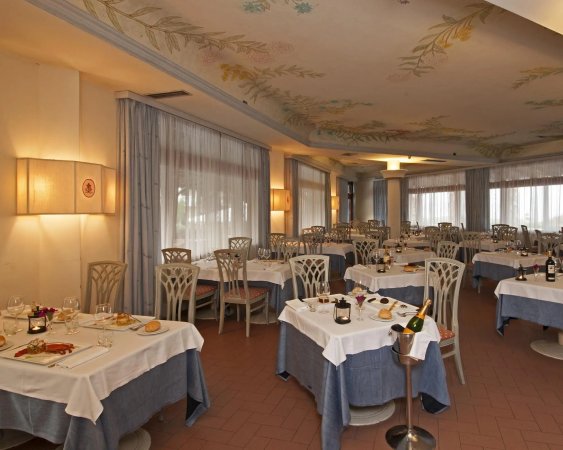 Ristorante elegante con tavoli apparecchiati e decorazioni floreali sul soffitto.