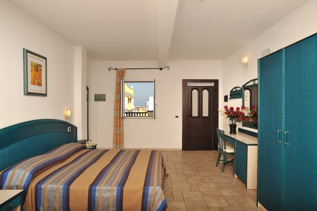 Camera con letto matrimoniale e scrivania.