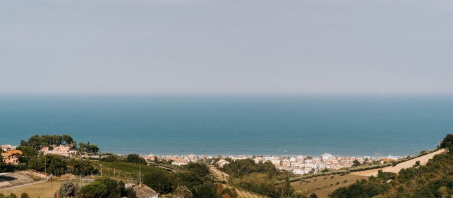Panoramica su mare e colline verdi.