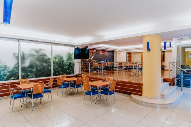 Sala ristorante con tavoli e sedie arancioni.