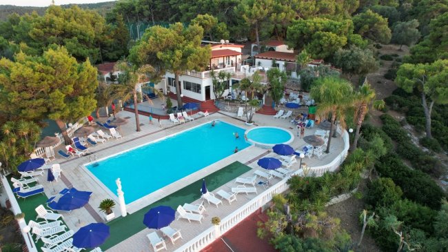 Piscina all'aperto con lettini e ombrelloni blu.