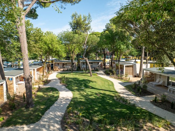 Sentiero tra bungalow e alberi.